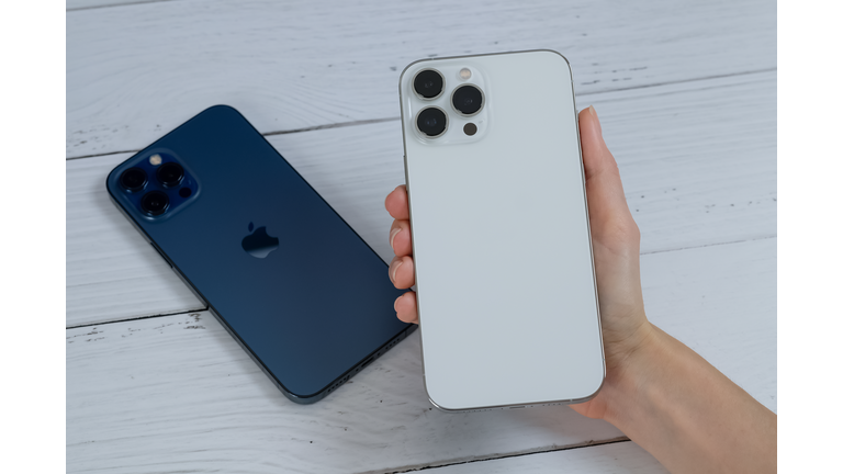 iPhone 13 Pro Max in Silver and iPhone 12 Pro Max in Pacific Blue