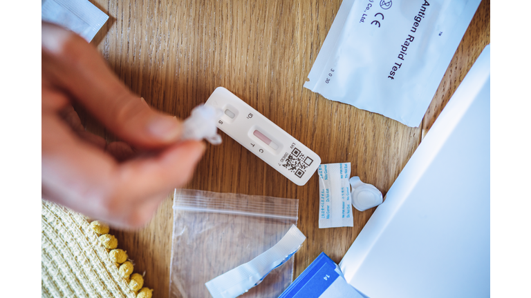 A woman using Covid-19 rapid self-test kit at home