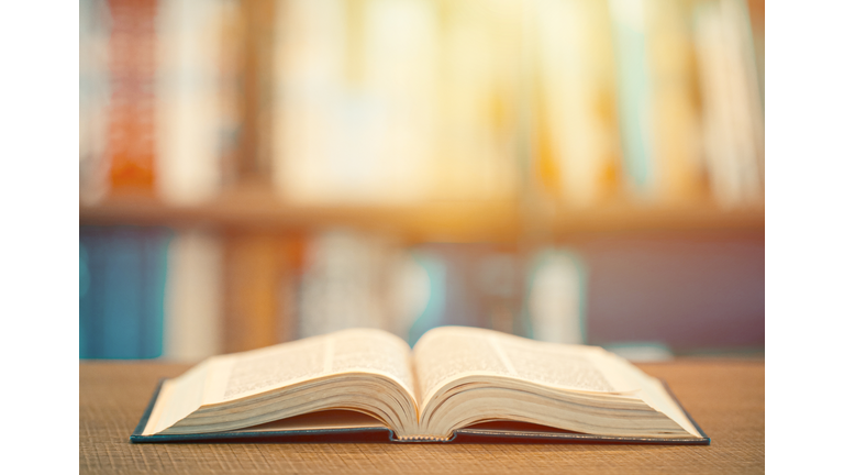 Concept of learning education. Open book on the wooden table in the library