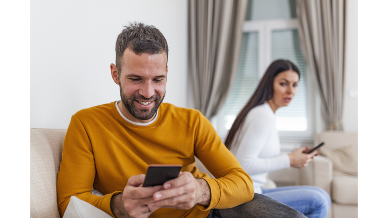 Jealous suspicious mad wife arguing with obsessed husband holding phone texting cheating on cellphone, distrustful girlfriend annoyed with boyfriend mobile addiction, distrust social media dependence