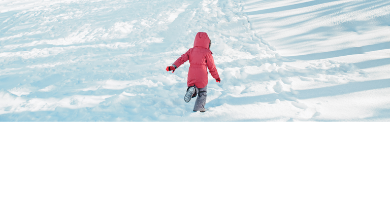 Happy girl child in warm clothes running in snow park. Child kid having fun during cold winter sunny bright day. Kids  seasonal activity. View from back behind. Web banner header.