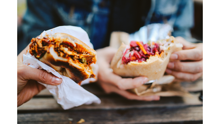 Close up of a Texas pulled pork bbq burger and a falafel outdoors