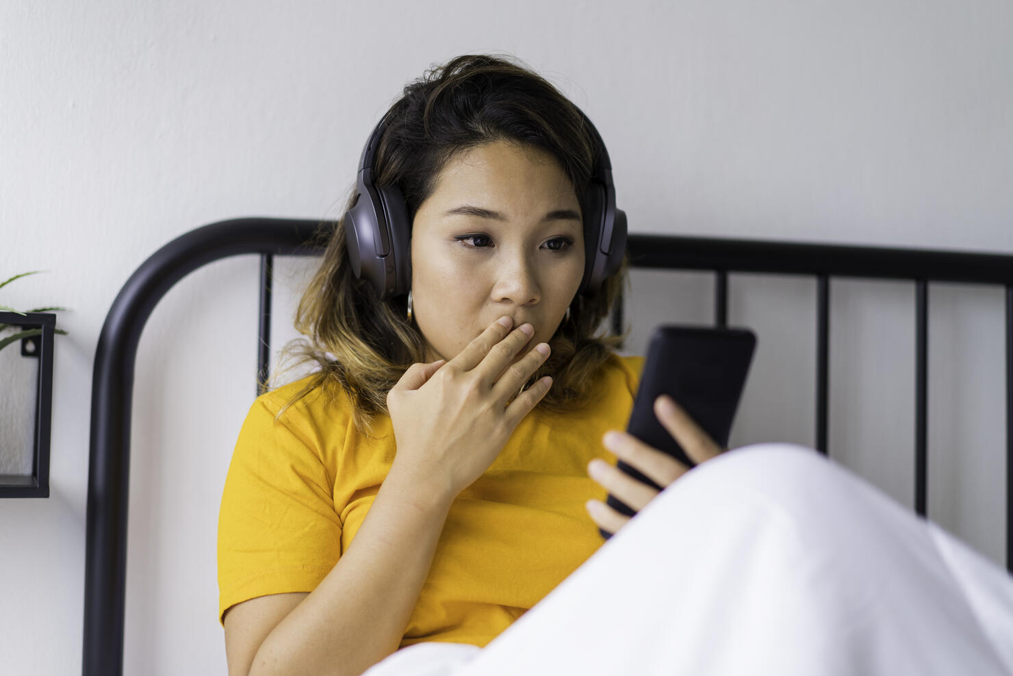 Young Asian woman surprised by an online text message.