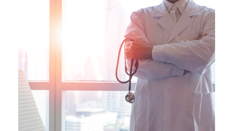 Professional medical physician doctor in white uniform gown coat hand holding stethoscope in clinic hospital.Medical/ healthcare/ technology concept