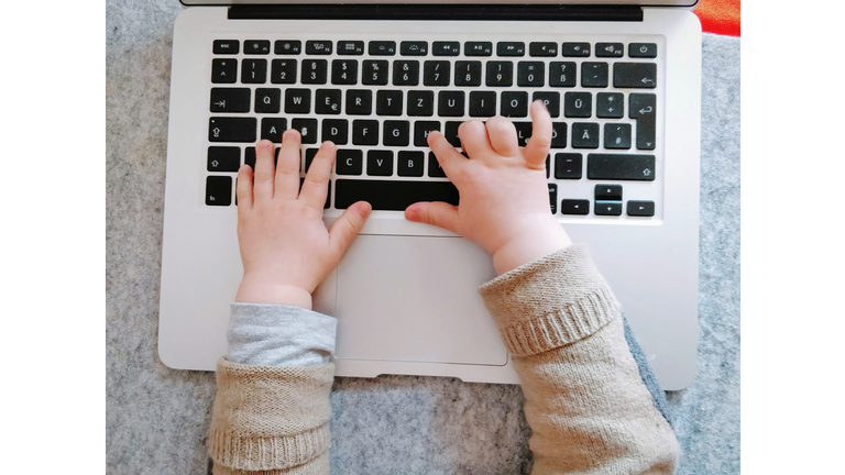 Close-Up Of Child Hands Using Laptop