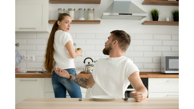 Angry husband and shocked wife arguing having conflict in kitche