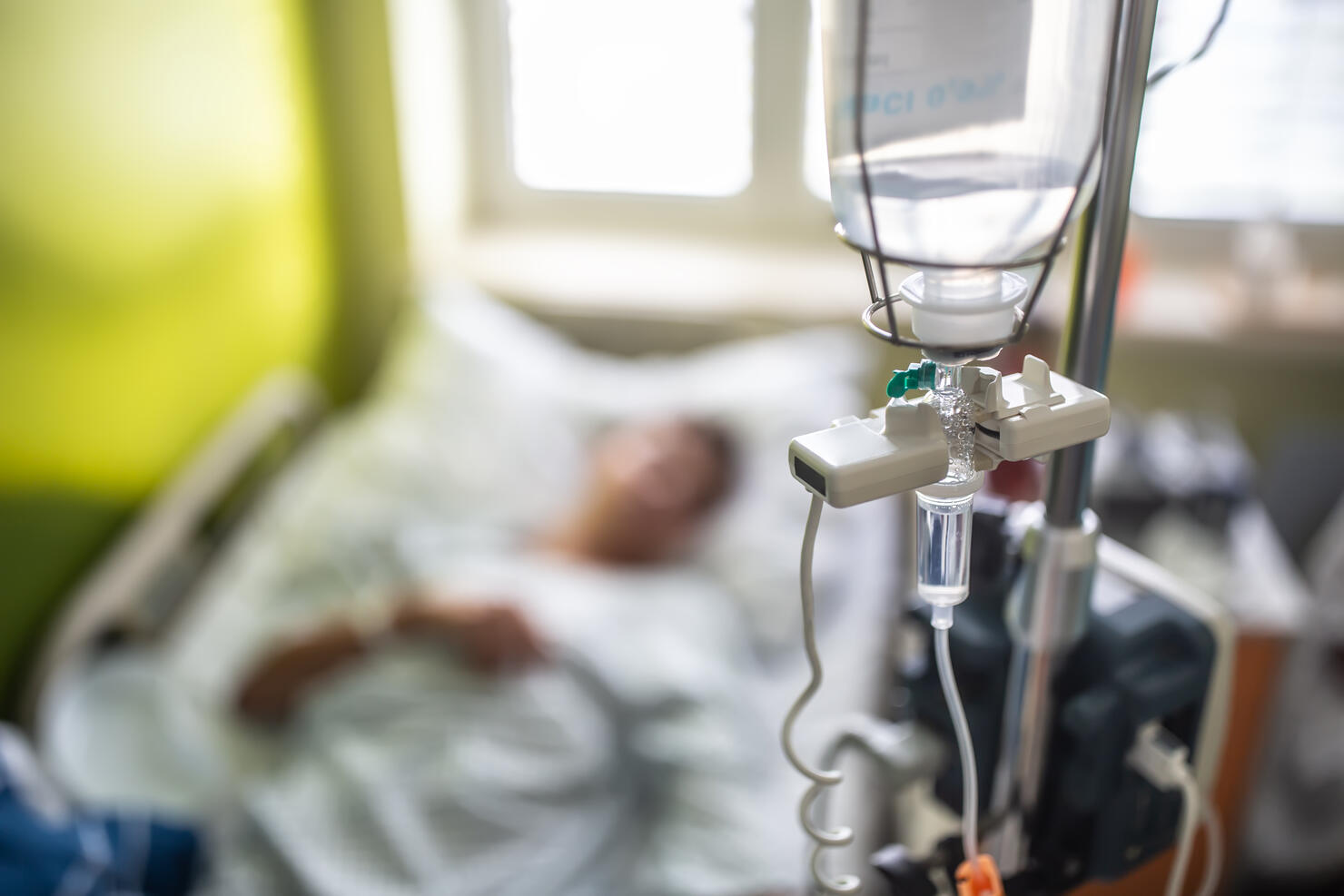 Drip infusion of a patient in a hospital room.