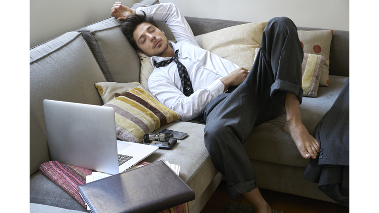 Man sleeping on the couch exhausted