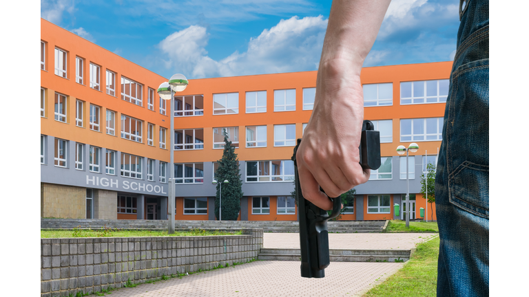 Gun control concept. Young armed man holds pistol in hand.