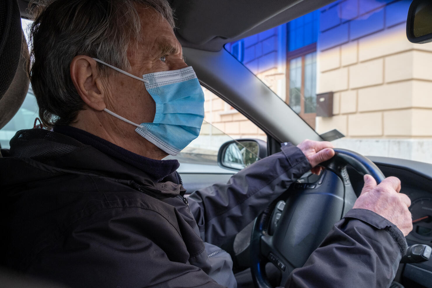 Senior Caucasian Man with Face Mask Driving his Car