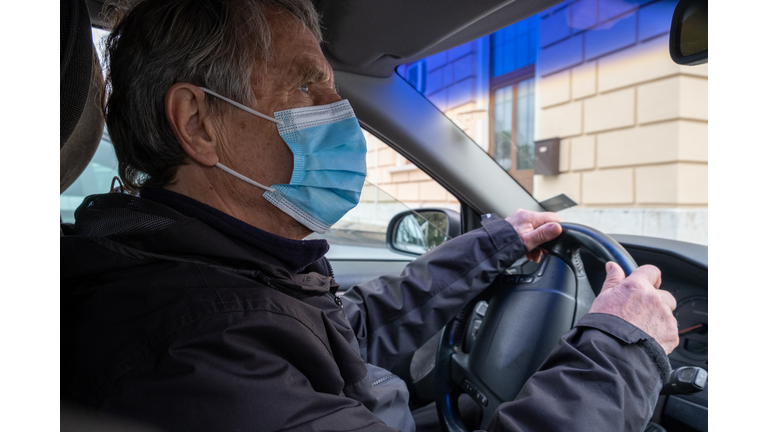 Senior Caucasian Man with Face Mask Driving his Car