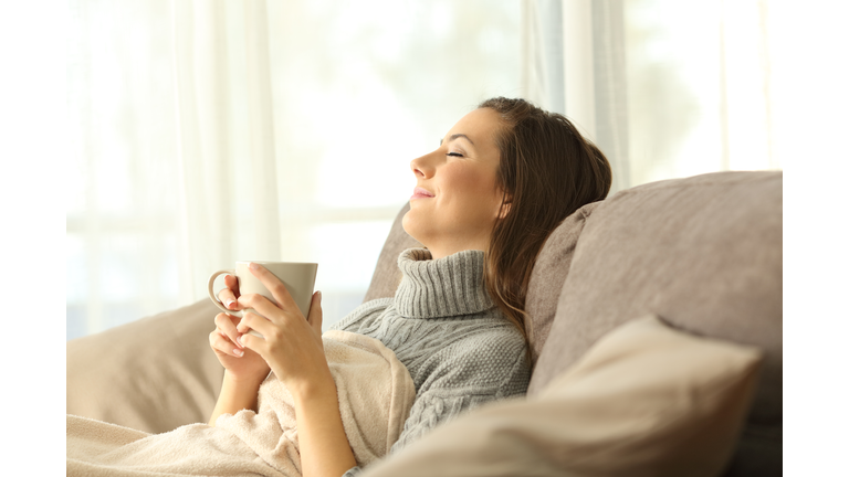 Woman relaxing at home holding a coffee mug