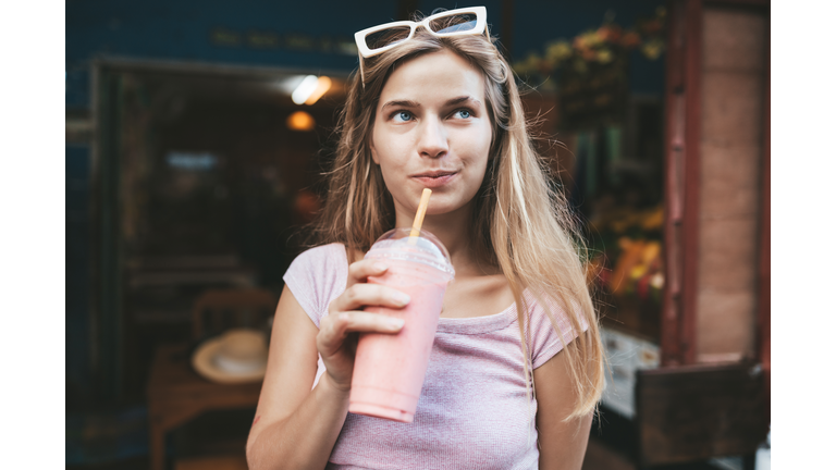 Young blonde woman drinking strawberry smoothie,Chiang Mai,Thailand