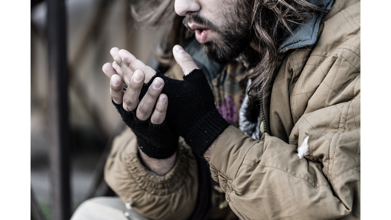 Pauper blowing on cold hands