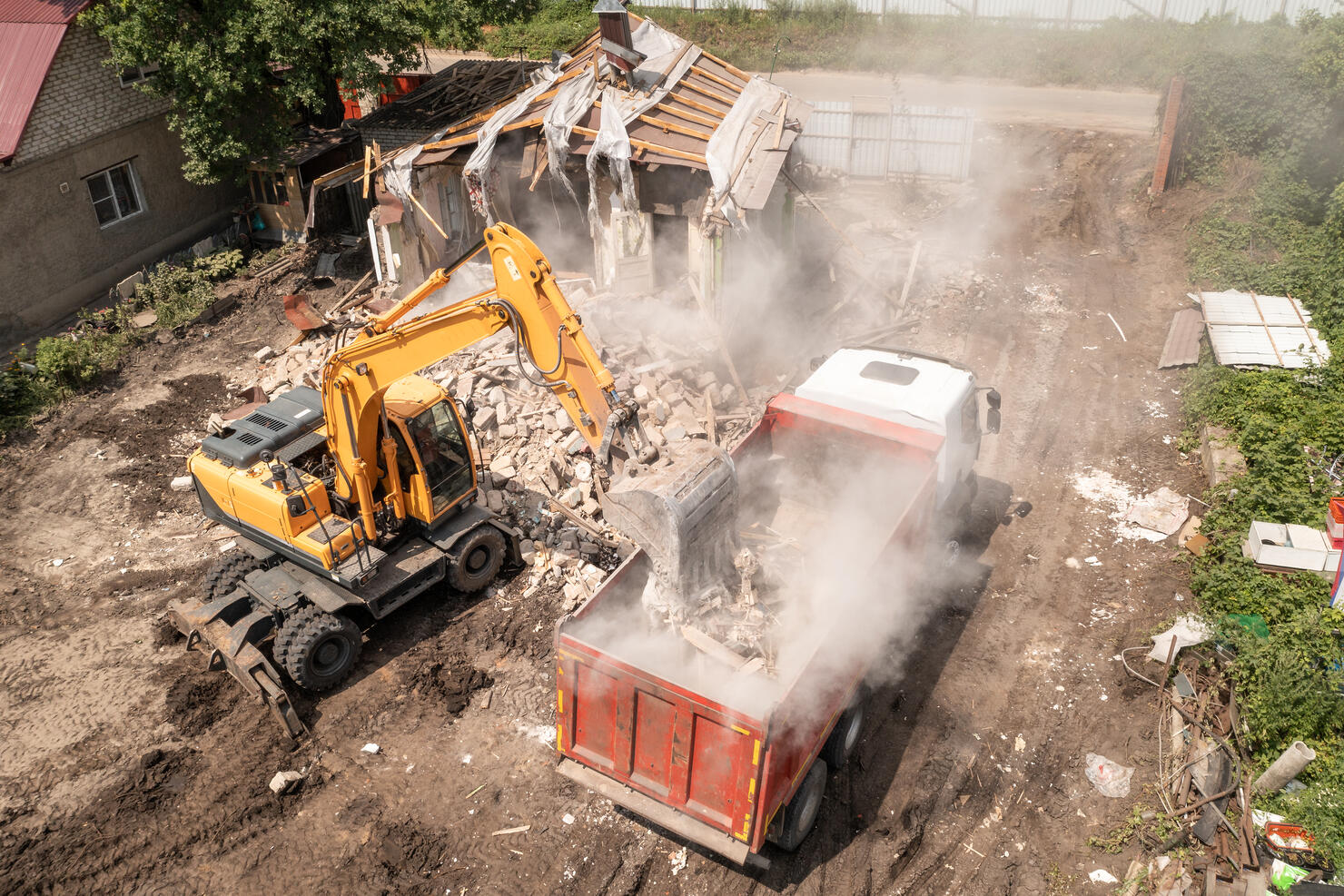 Demolition Of House Building For New Construction. Excavator Bucket Load Garbage into Truck, Aerial View