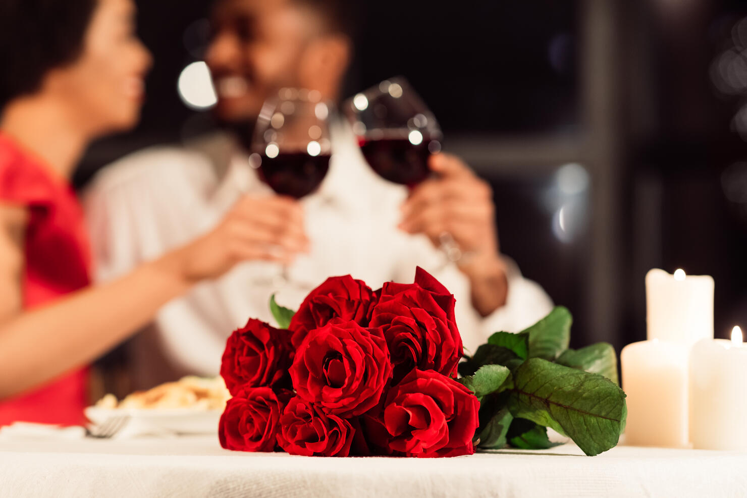 Roses Lying On Table, Unrecognizable Spouses Drinking Wine In Restaurant