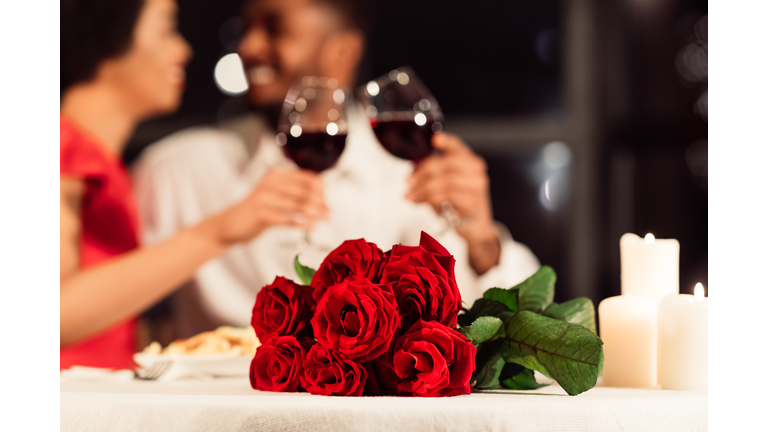 Roses Lying On Table, Unrecognizable Spouses Drinking Wine In Restaurant
