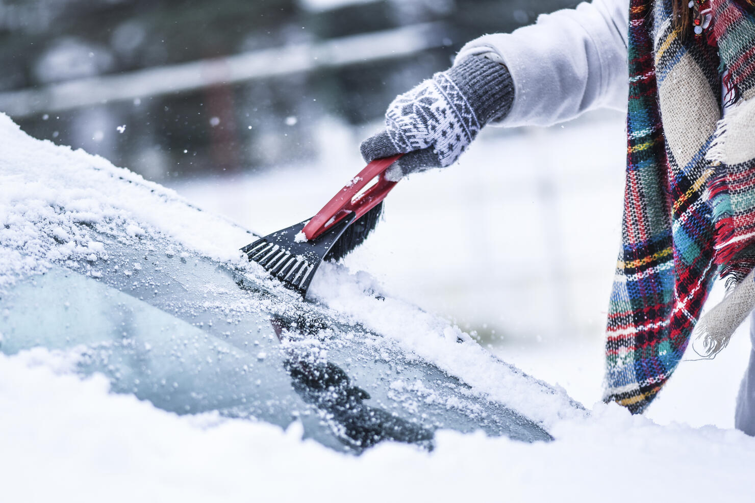 Woman cleaning snow from windshield, Scraping frozen ice glass.