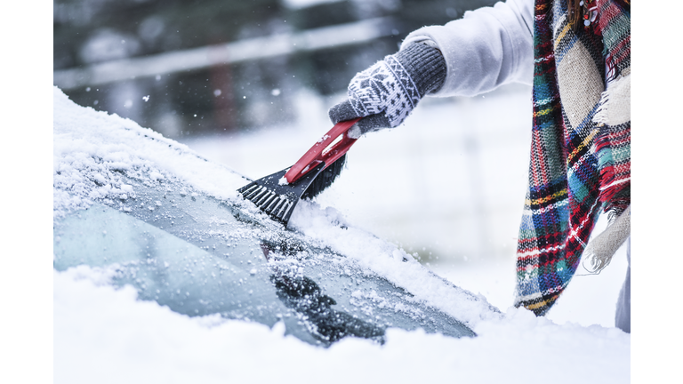 Woman cleaning snow from windshield, Scraping frozen ice glass.