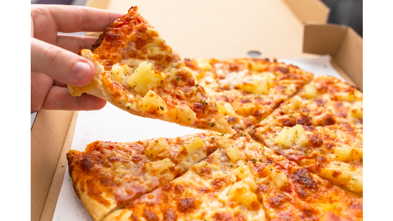 Close up of tasty hawaiian pizza with ham and pineapple
