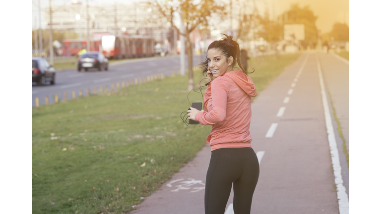 Female runner jogging and listening to music