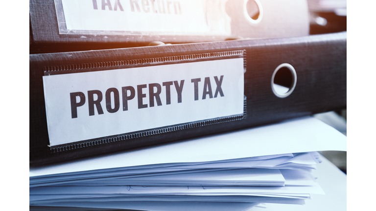 Property tax and tax return word on folders stack with label black binder on paperwork documents summary report in busy offices. HR-human resources business bookkeeping accountancy Document Concept