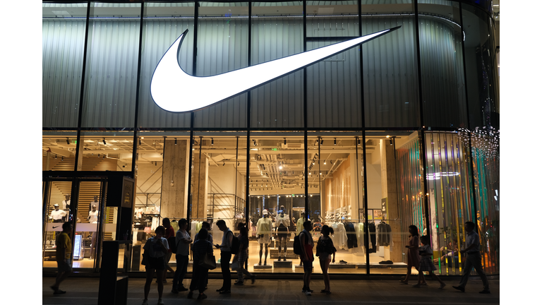 Large NIKE store at night with many people‘s silhouette