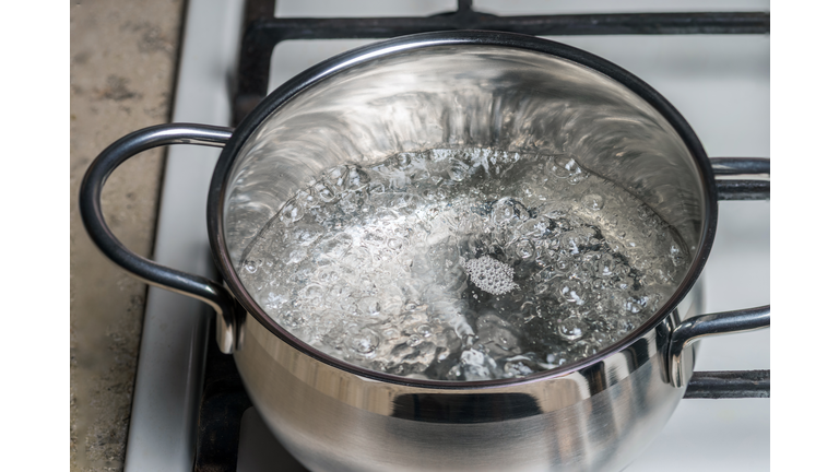 Boiling water in a stainless saucepan on a gas
