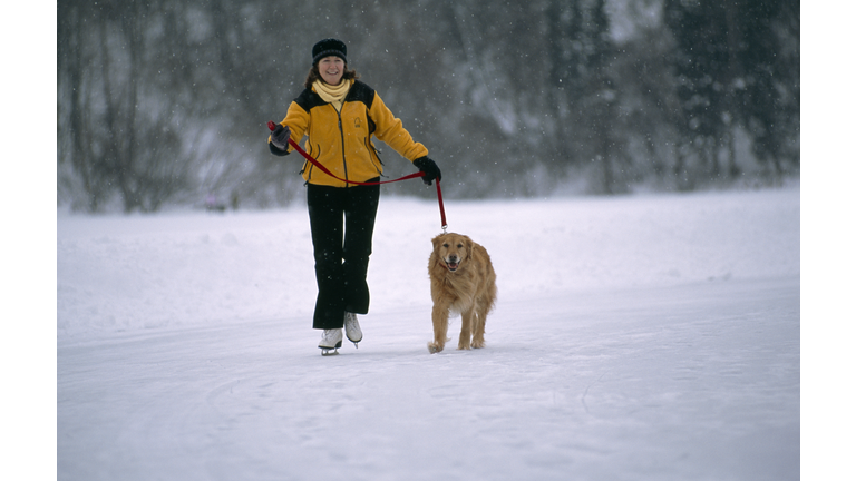 Woman ice-skating with dog