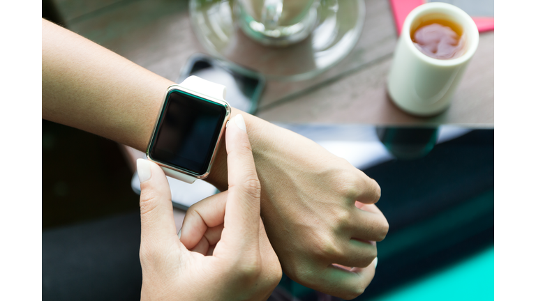 Hand using Apple Watch in coffee shop