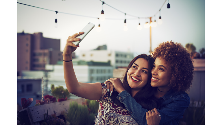 Friends taking a selfie on urban rooftop