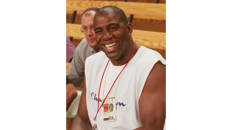 Former NBA star Magic Johnson watches a basketball