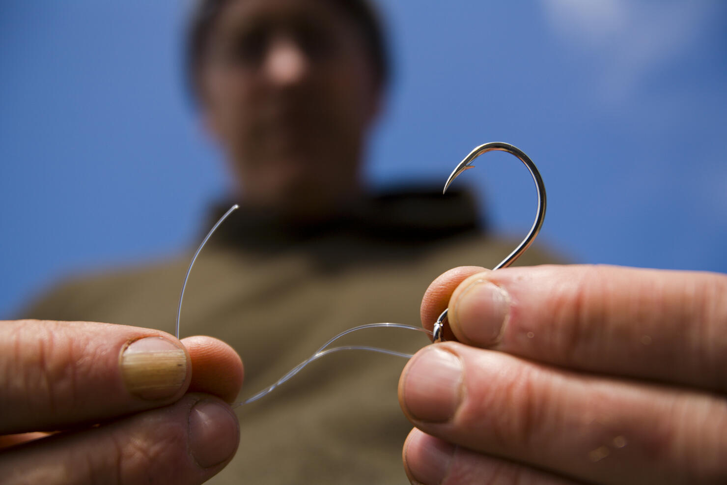 A man ties fishing line to a hook on The Lost Coast, California.
