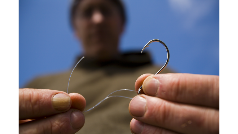 A man ties fishing line to a hook on The Lost Coast, California.