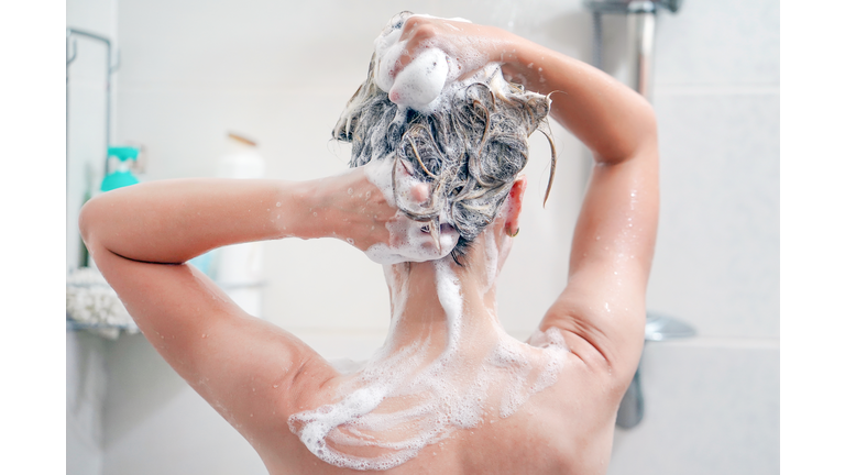 Back view of young woman washing her hair