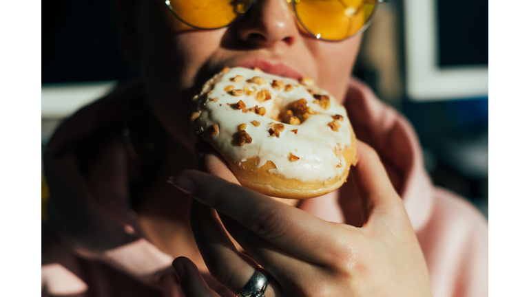 Close-Up Of Woman Eating Donut