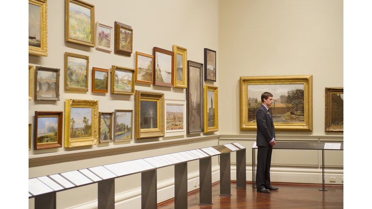 Caucasian security guard standing in art museum