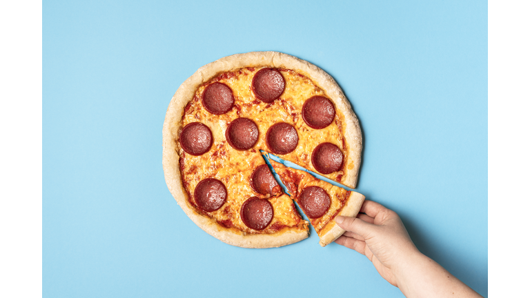 Pizza pepperoni and taking a slice of pizza. Eating pizza salami