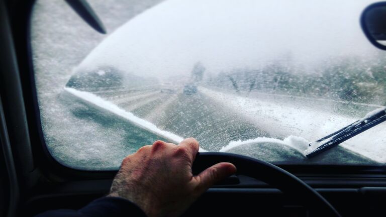 Cropped Image Of Man Driving Car During Winter