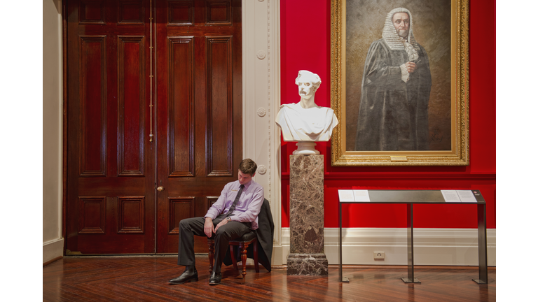 Caucasian security guard napping in art museum