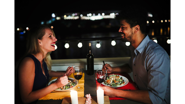 Young beautiful couple having romantic dinner on rooftop