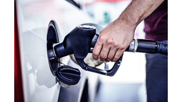 Man fulling tank with fuel at bokeh background