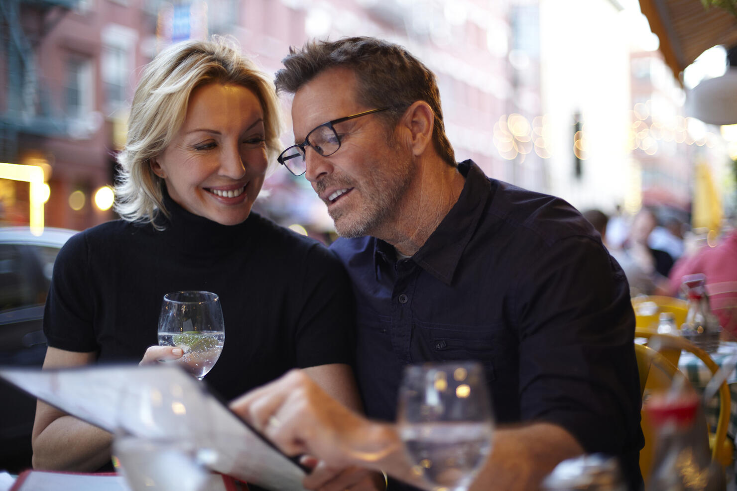 Caucasian couple reading menu at urban cafe, New York City, New York, United States