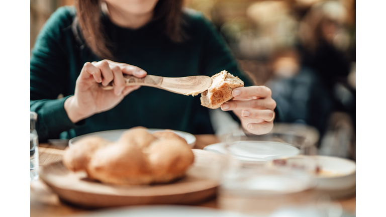 Young Woman Buttering Bread At The Restaurant