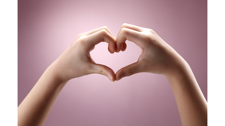 Cropped Hands Gesturing Heart Shape Against Pink Background