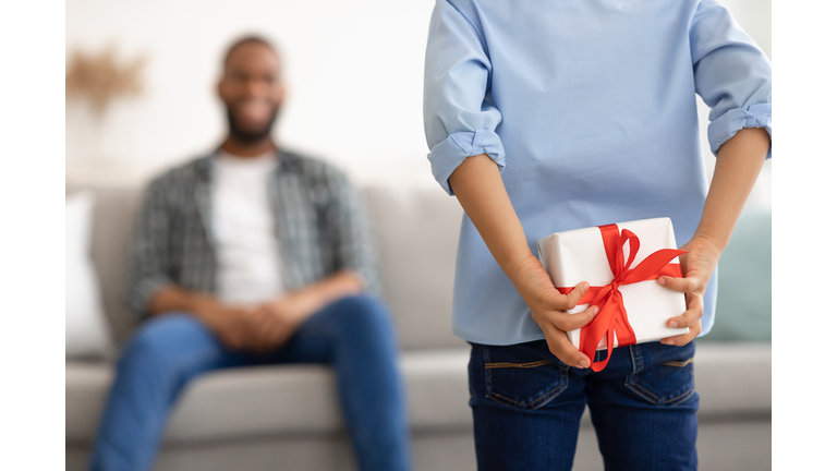 Son Holding Gift For Dad Behind Back At Home, Cropped