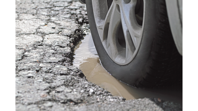 Alloy Wheel And Tire In A Pothole, Closeup