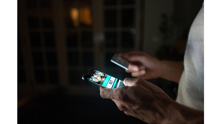 Man betting online at home on his cell phone