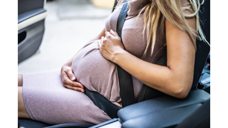 Pregnant woman with safety seat belt