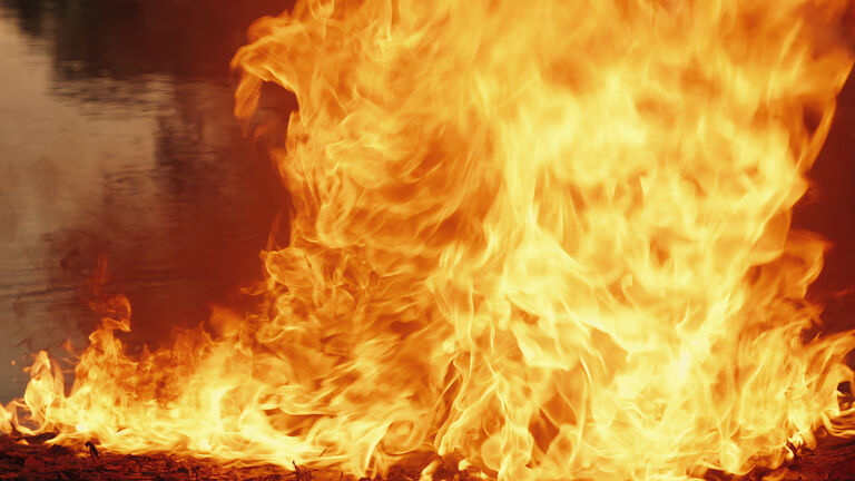 Column of fire on the water surface, on the border with the earth